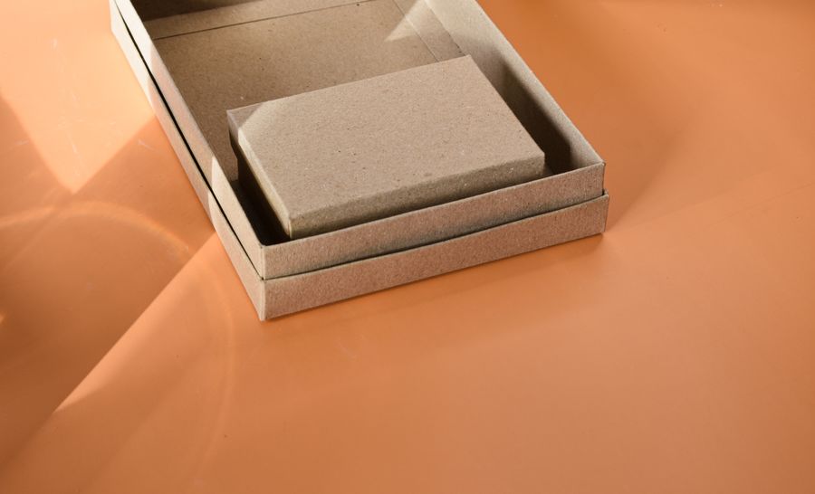 Minimal kraft paper box on an orange studio surface
